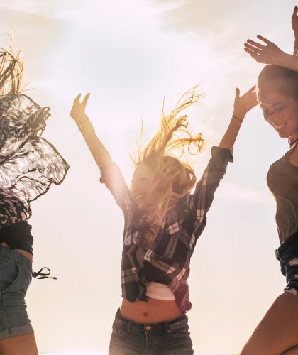 Youthful people beautiful young girl jumping and celebrating for happiness outdoor with sun